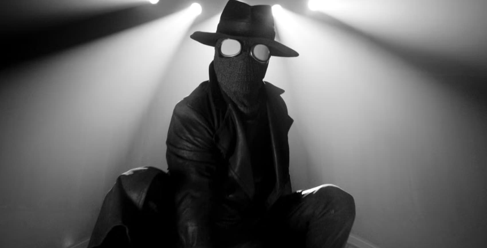 Spider-Noir seated beneath an interrogation lamp